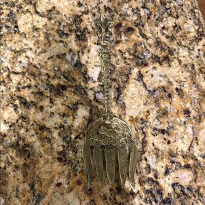Vintage serving fork with gold wash.cherubs and Fleur-de-lis design.10" x 2.75"